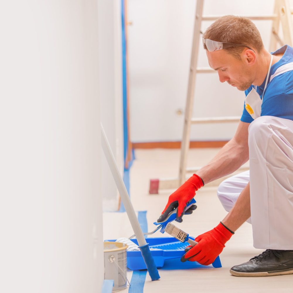 House Walls Painting. Young Caucasian Men Painting His Home. Construction and Renovation.