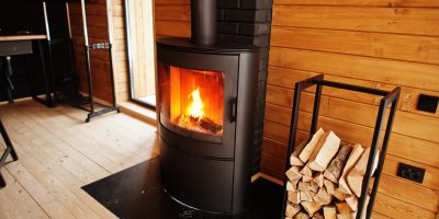 Fireplace with woods in modern wooden house.